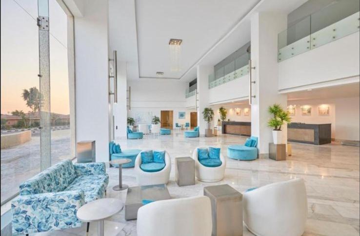 阿莱曼Golden Palace Marina Hotel的大楼内带蓝色家具的大堂