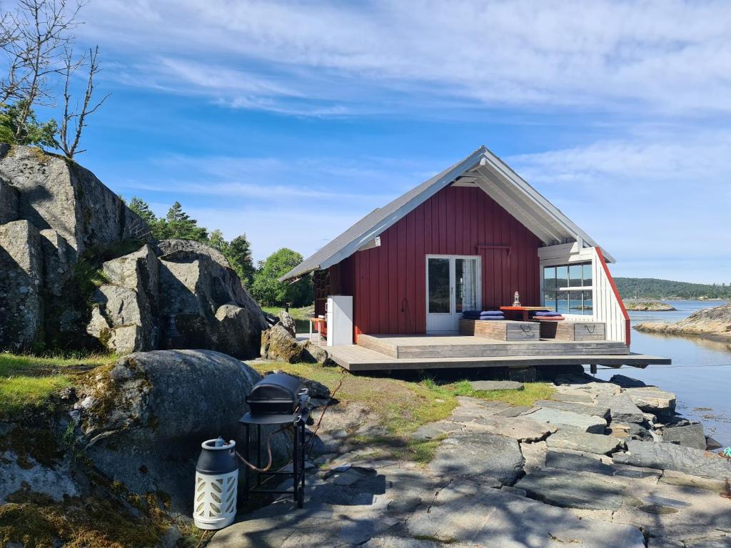 克拉格勒Usjenert idyllisk Sjøbu的水体岸边的红色小屋