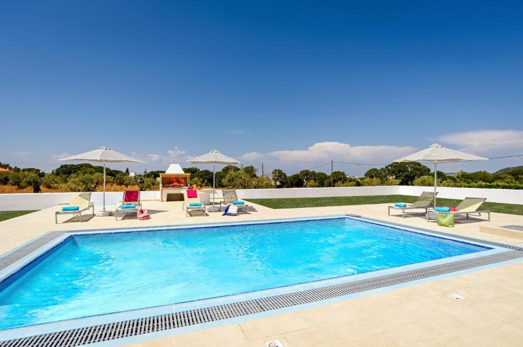 伊利索斯Villa Paleos Aegean by Villa Plus的一个带椅子和遮阳伞的大型游泳池