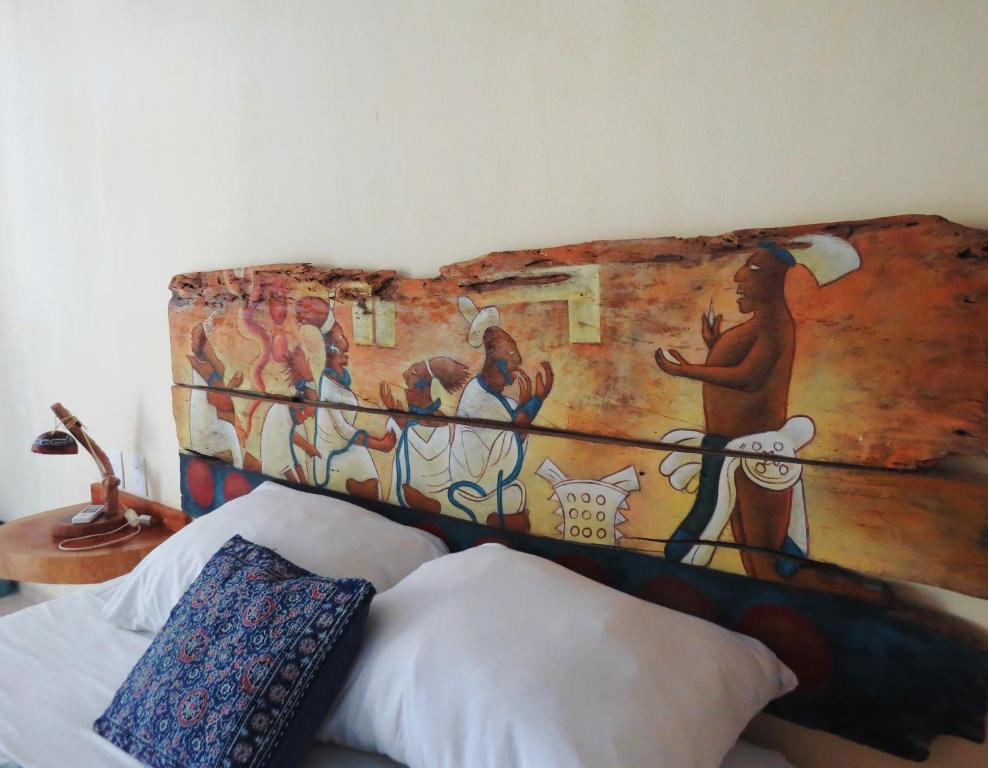 奥尔沃克斯岛Art Maya Rooms的墙上有画的一张床
