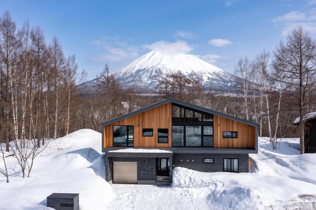 俱知安町Shion的雪中的房子,背景是山