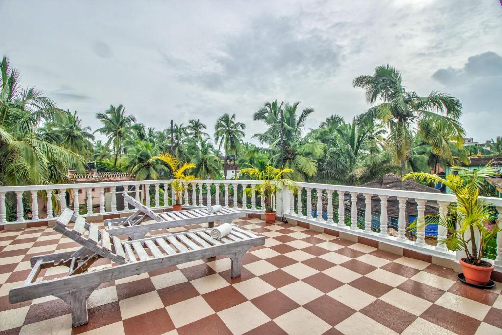 坎多林Villa Verediana的阳台设有2个长椅和棕榈树