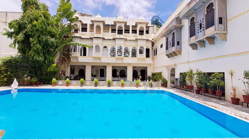 乌代浦摩哂陀普拉喀什酒店的大楼前的游泳池