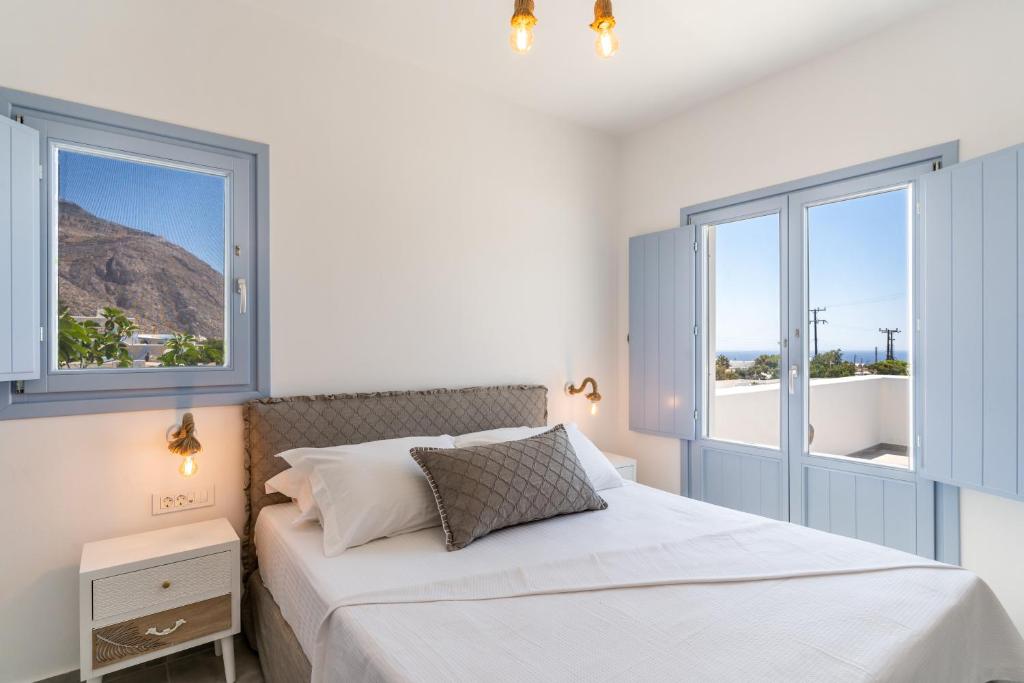 安坡里奥圣托里尼SantoRossa Luxury Villas的一间白色卧室,配有床和2个窗户