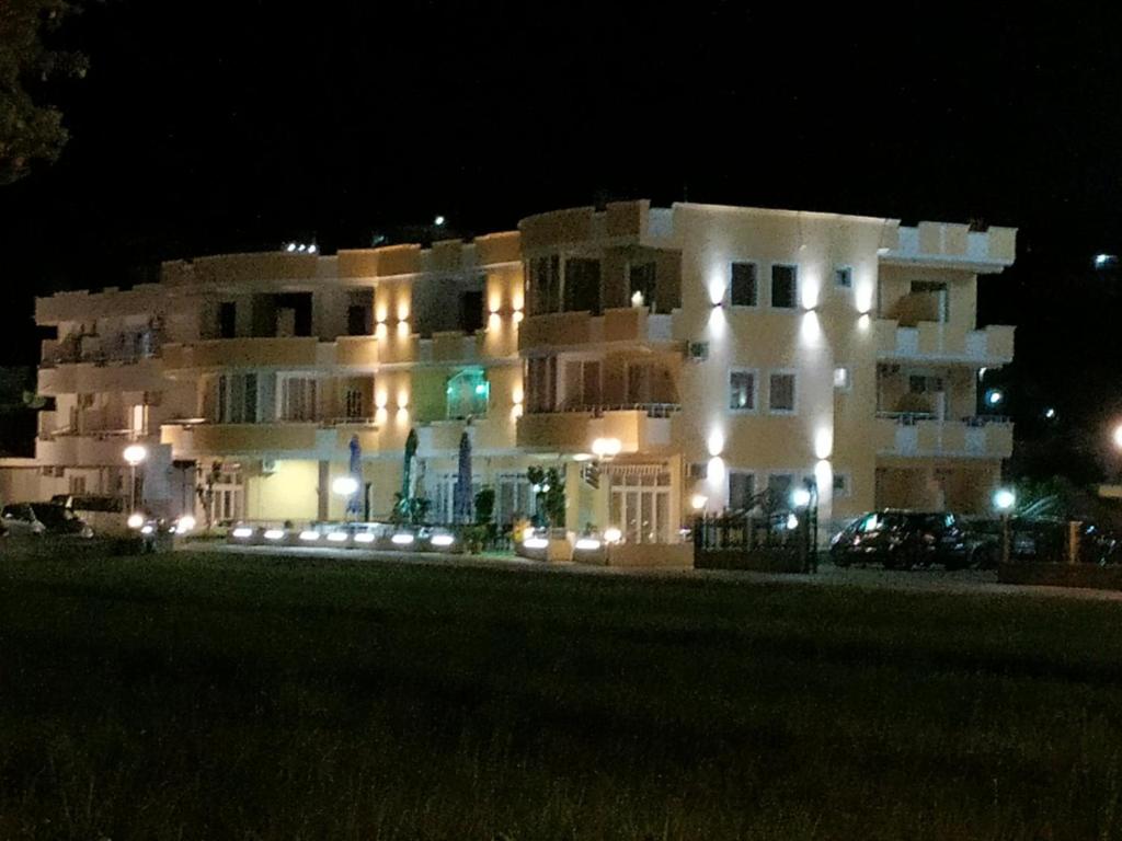 乌尔齐尼Grandino rooms&apart的一座白色的大建筑,晚上有灯光