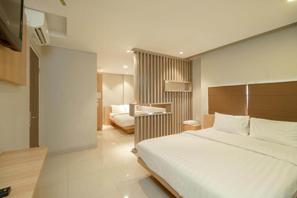 雅加达Green Apple Residence near Sarinah Mitra RedDoorz的配有一张床和一张书桌的酒店客房