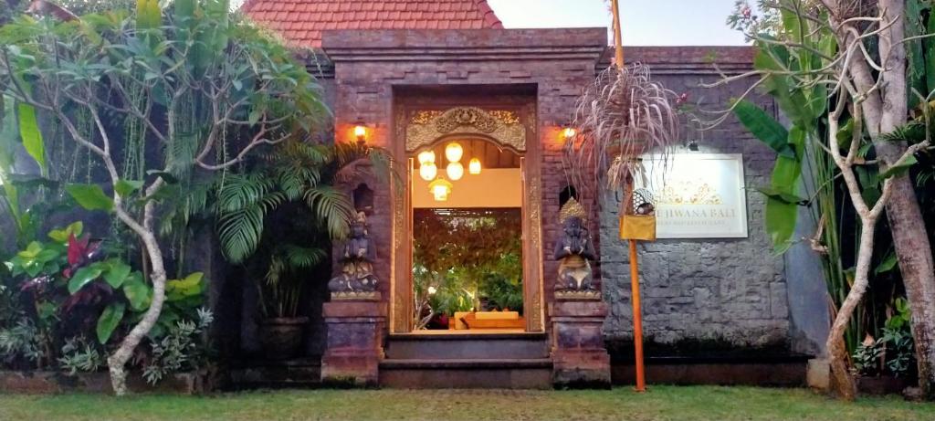 乌干沙The Jiwana Bali Resort的树 ⁇ 院内有门道的建筑