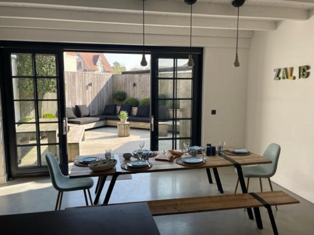 克诺克－海斯特Authentiek vissershuisje Oud-Knokke的客厅配有餐桌和椅子
