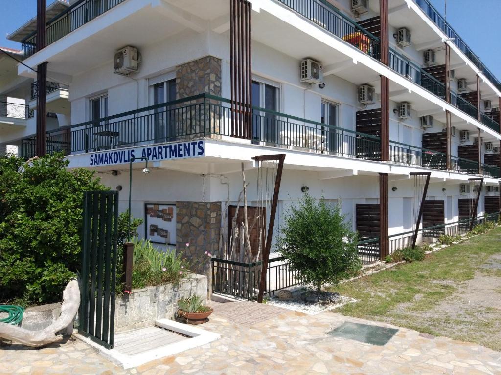 尼亚米卡尼奥纳Samakovlis Apartments的一座白色的大建筑,上面有标志