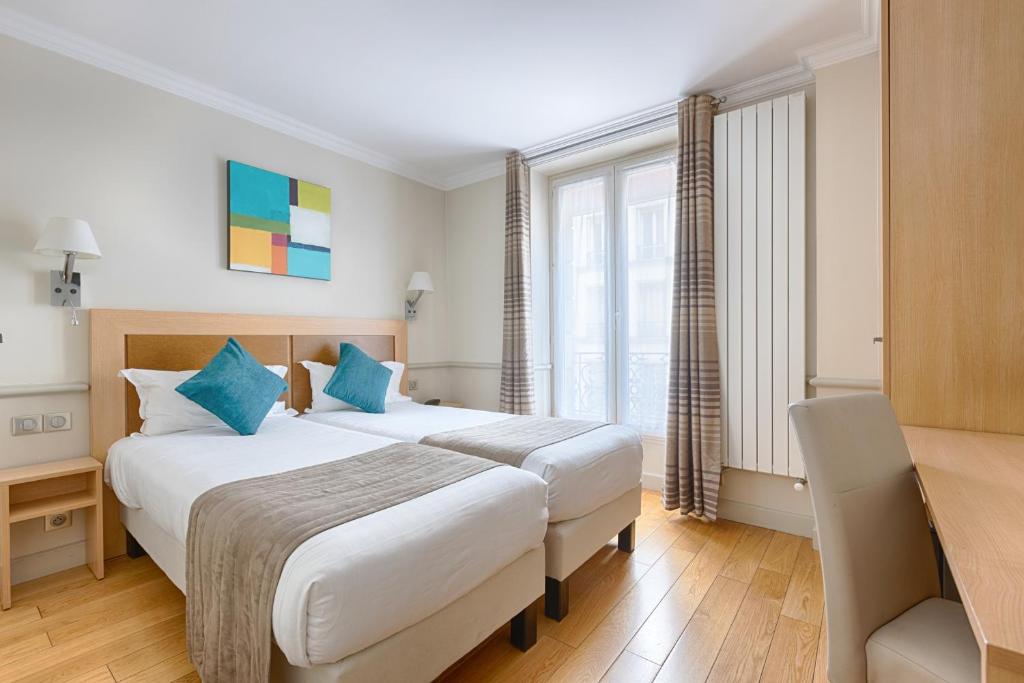 巴黎阿波丽娜尔酒店的酒店客房配有两张床和一张书桌