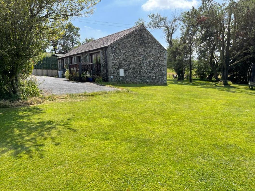 彭里斯Lake District cottage in 1 acre gardens off M6的绿草丛中的石头房子