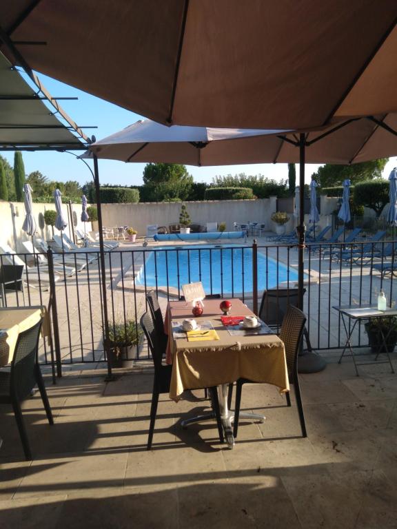 奥佩德马斯丹萨凡住宿加早餐旅馆的游泳池旁遮阳伞下的桌椅
