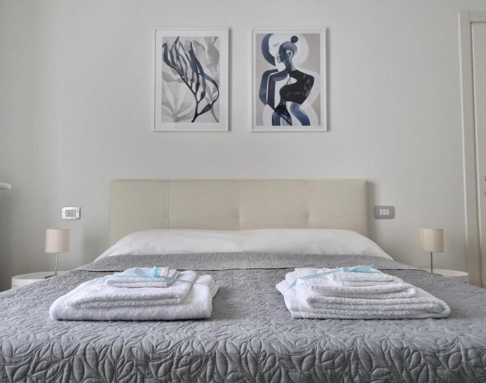 米兰Claro Apartments - Prampolini 12的一间卧室配有带毛巾的床
