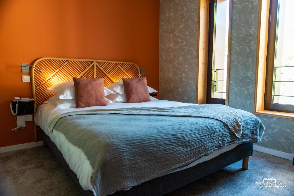 皮耶尔佩尔塞埃Logis Hôtel Altitude et Spa Pierre-Percée的一间卧室配有一张带橙色墙壁的大床