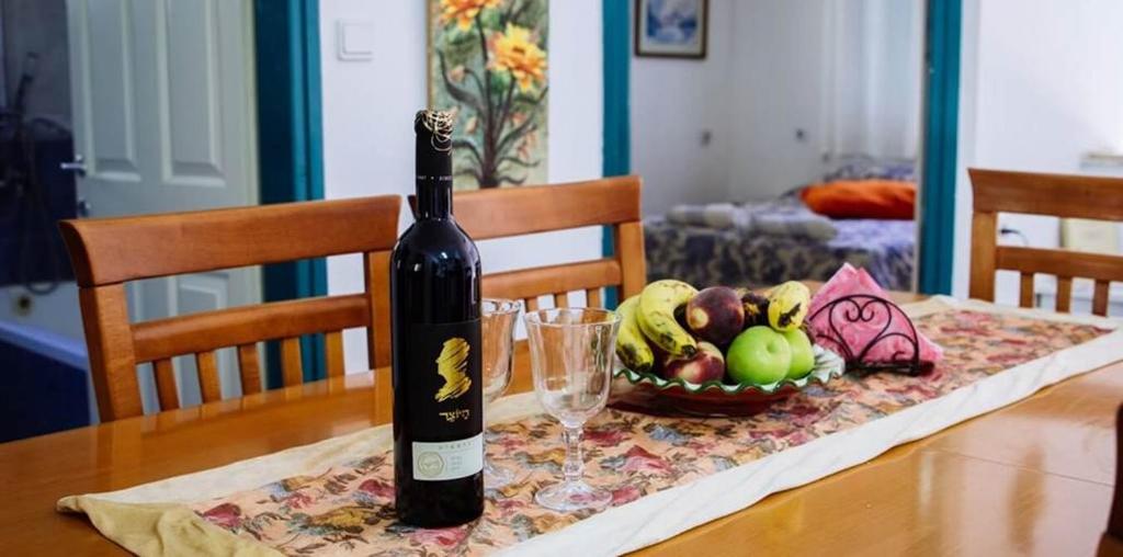 梅图拉חלום בגורן -יחידת אירוח的一瓶葡萄酒,坐在桌子上,放上一碗水果
