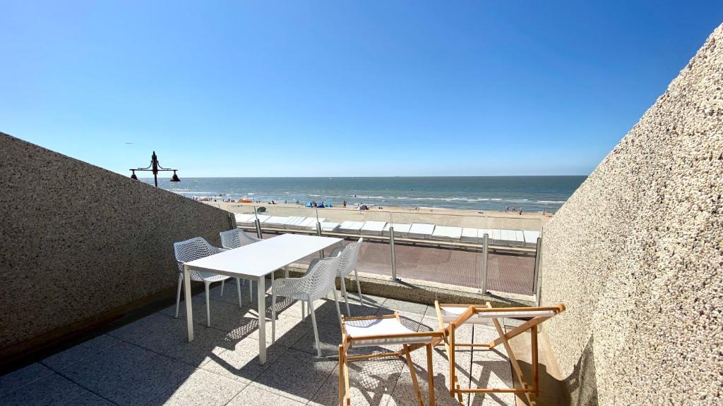 德哈恩DeHaanStudio的俯瞰海滩的阳台配有桌椅