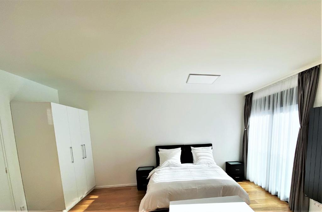 马拉科夫Studio de standing的白色的卧室设有床和窗户