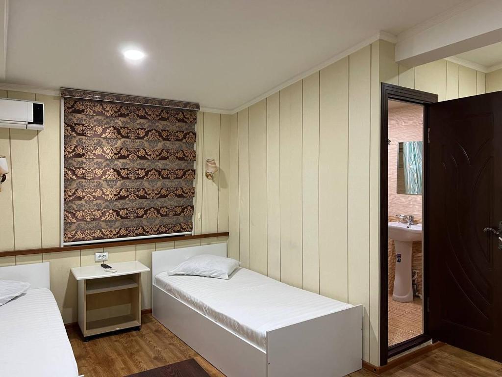 YakkasarayHiva的小房间设有两张床和盥洗盆