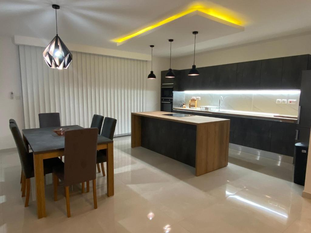 卢加Modern, Spacious, 3 Bedroom Apartment near Malta International Airport的厨房以及带桌椅的用餐室。