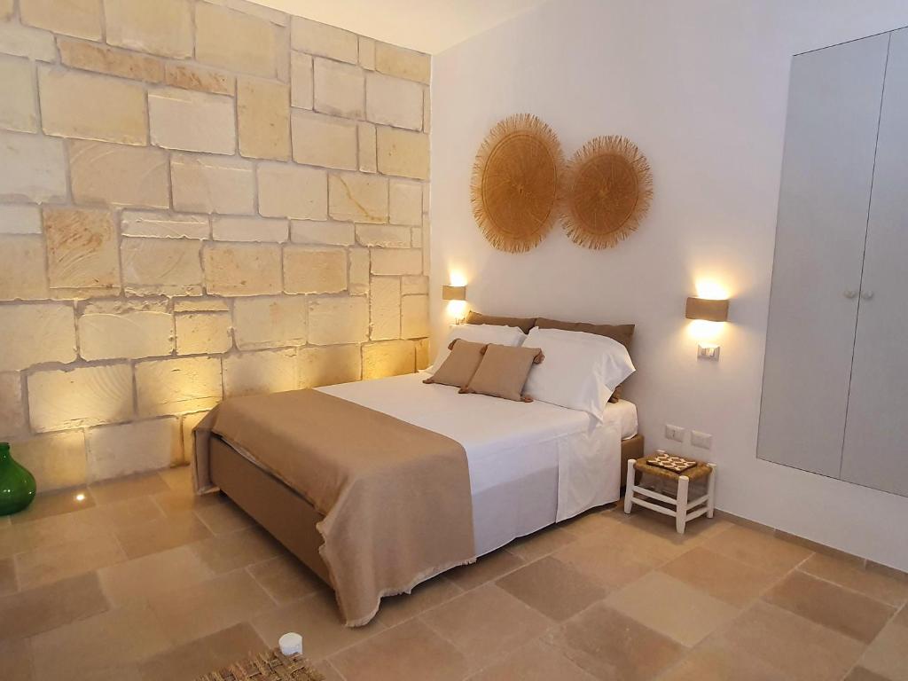 奥特朗托La Noscia - Le Dimore di Thesia的卧室配有白色的床和砖墙