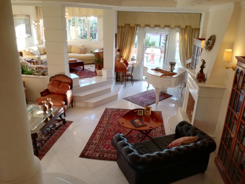 塞萨洛尼基Πολυτελής κατοικία με θέα τον Θερμαϊκό的客厅配有沙发和桌子