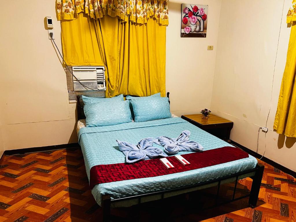 宿务May’s Homestay的一间卧室配有一张黄色窗帘的床