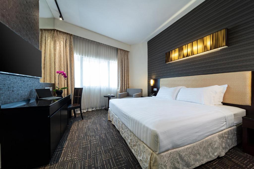 新加坡Hotel Royal Queens的配有一张床和一张书桌的酒店客房