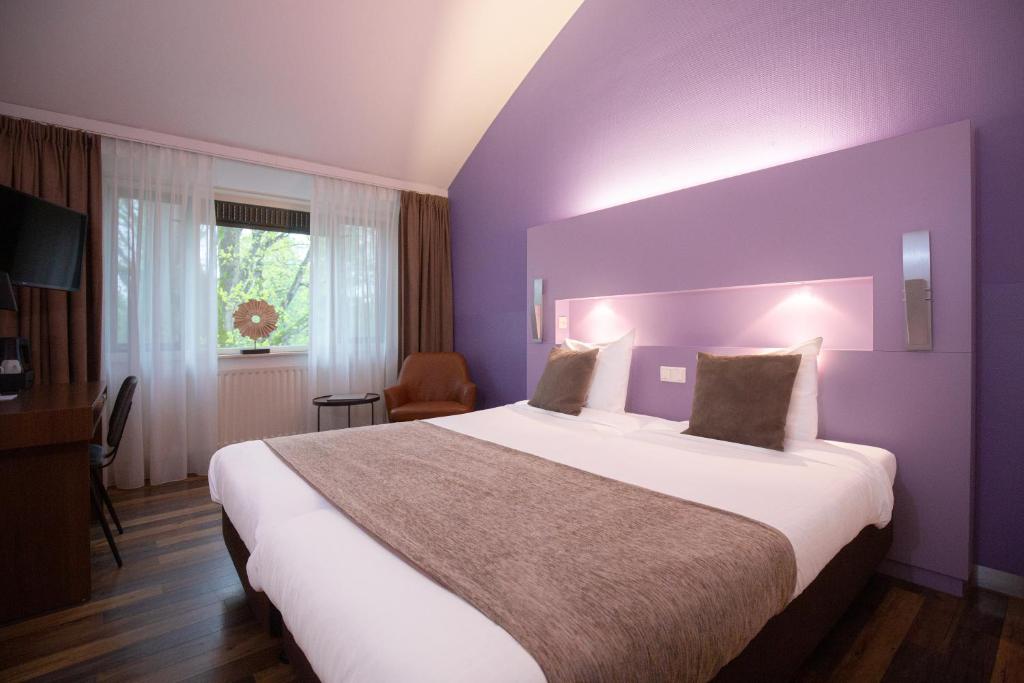 埃德贝尔蒙特酒店 的紫色客房内的一间卧室配有一张大床