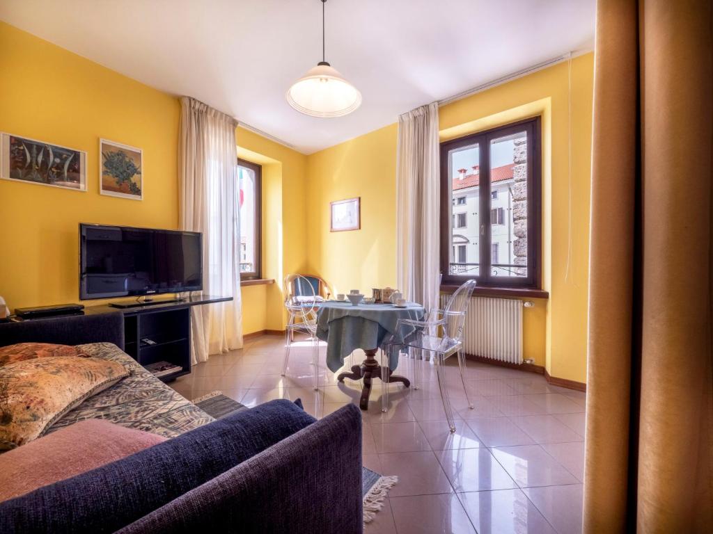 弗留利地区圣达尼埃莱Apartment Squisleep-1 by Interhome的客厅设有黄色的墙壁和桌椅
