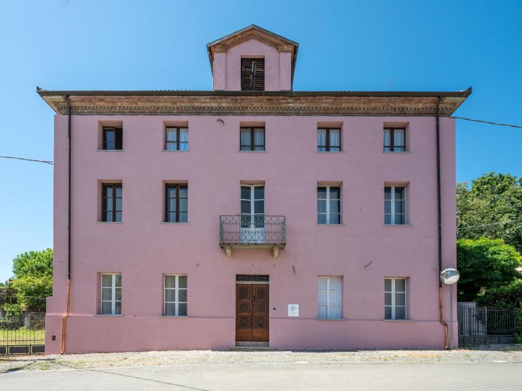 圣安德烈亚Holiday Home Mariscotti by Interhome的粉红色的建筑,顶部有钟楼