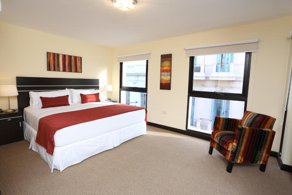 蒙得维的亚海港市场酒店的一间卧室配有一张大床和两把椅子