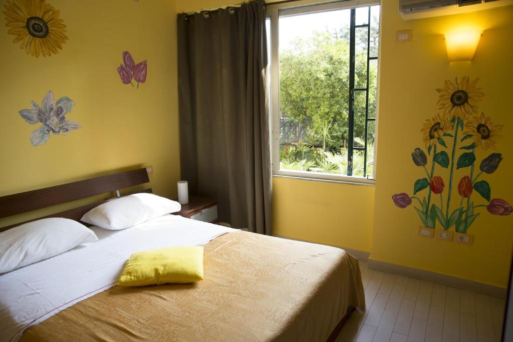 那不勒斯彩虹住宿加早餐酒店的一间卧室设有一张床,墙上设有鲜花窗户。