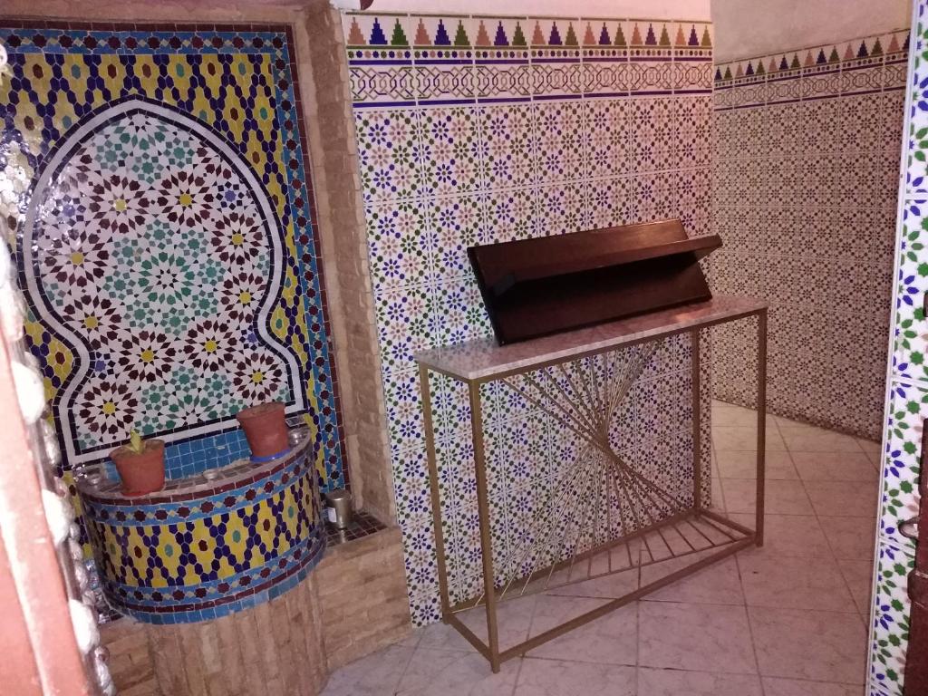 拉巴特Dar Sam - Purple Room的浴室设有马赛克墙、架子和桌子