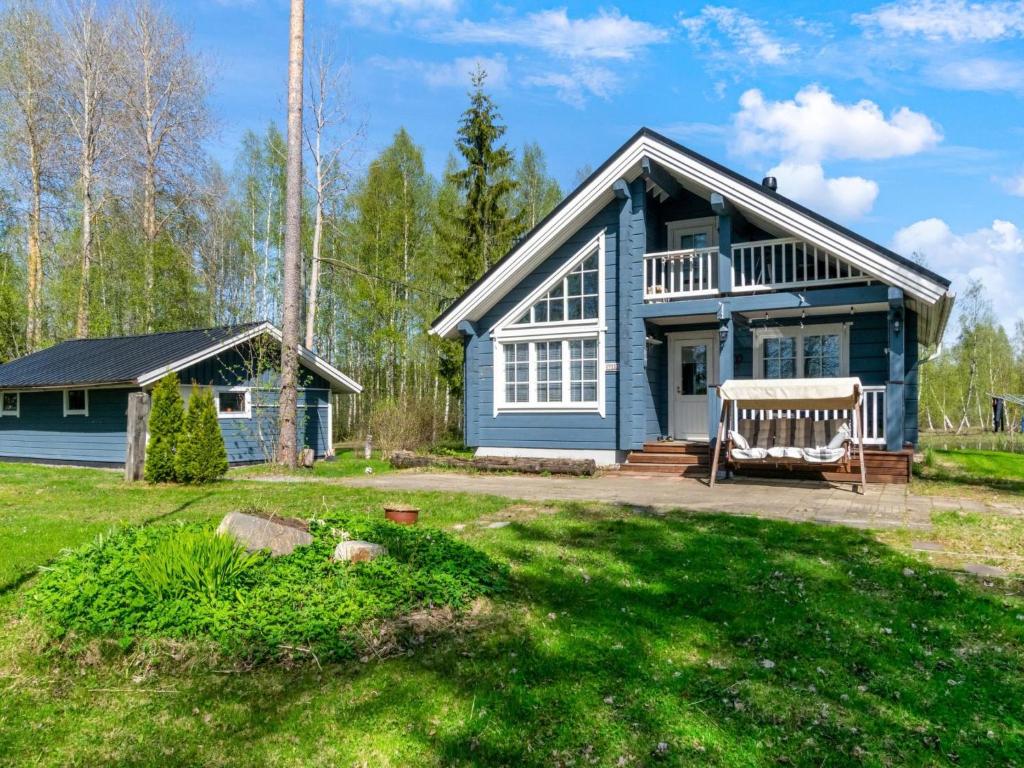 伊萨尔米Holiday Home Tuliniemi by Interhome的院子里带长凳的蓝色房子