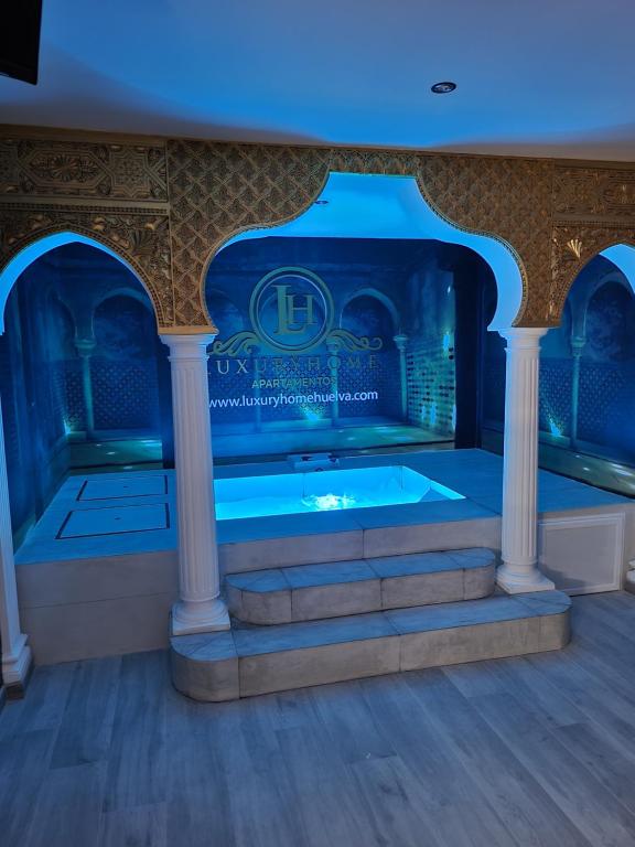 韦尔瓦Apartamento Luxury Suite Huelva Zona Centro的蓝色灯光的客房内的按摩浴缸