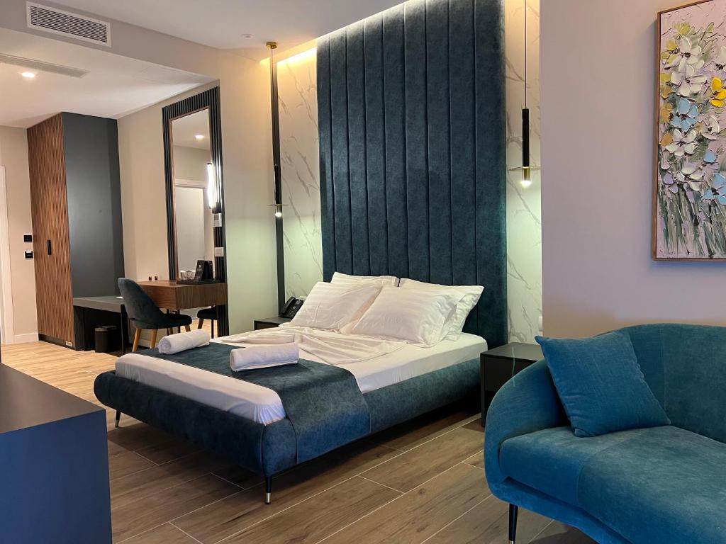 圣金Domus Hotel & Apartments的一间卧室配有一张床和一张蓝色的沙发