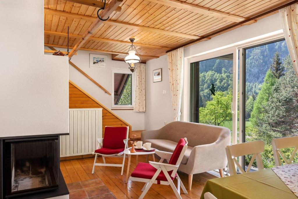 克拉尼斯卡戈拉Primula Cottage, a step away from Kranjska Gora的客厅设有壁炉、桌子和椅子