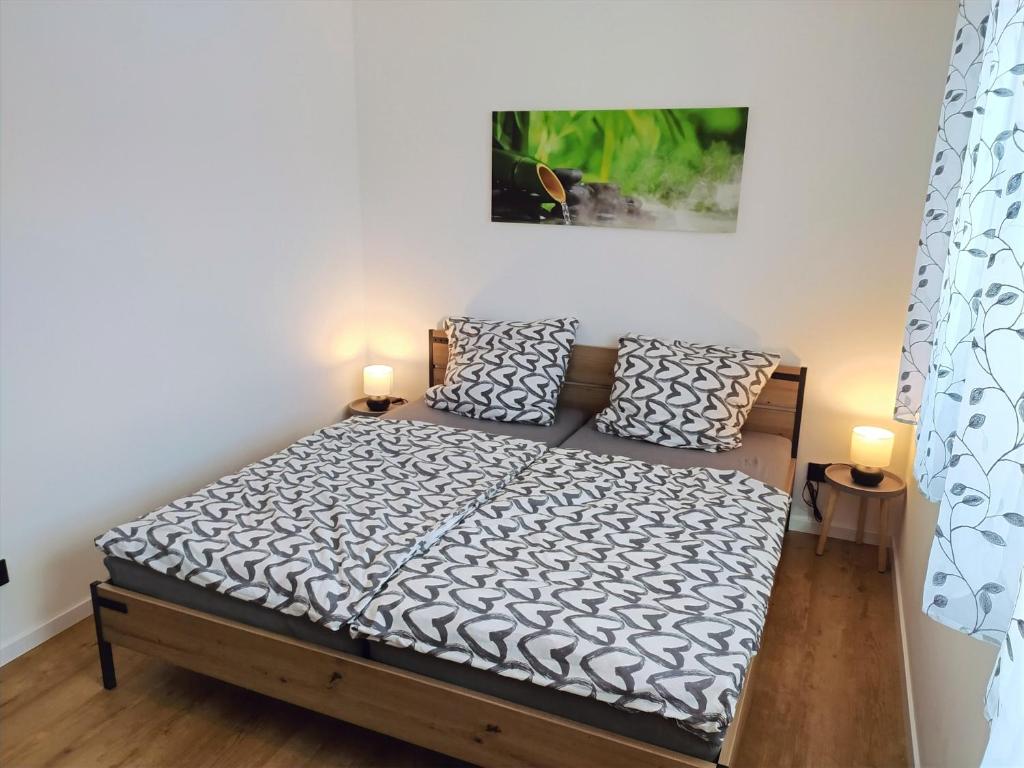 WildfleckenFeWo Wildflecken - Ferienwohnung Rhön Neubau 2021的一间卧室配有一张带两盏灯的床。