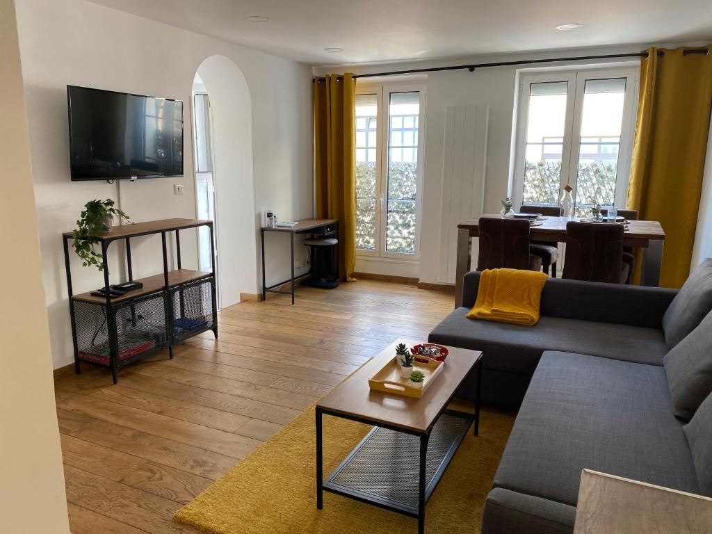 沙朗通勒蓬Le Roofound - Porte de Paris - Métro à 5min - Entrée personnelle的客厅配有沙发和桌子