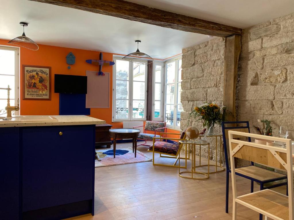 努瓦埃尔Logement entier - L'Appart des anges 1的厨房和带橙色墙壁的客厅