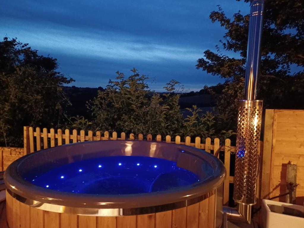 巴斯Norwell view farm glamping with hot tubs的晚上在后院的按摩浴缸