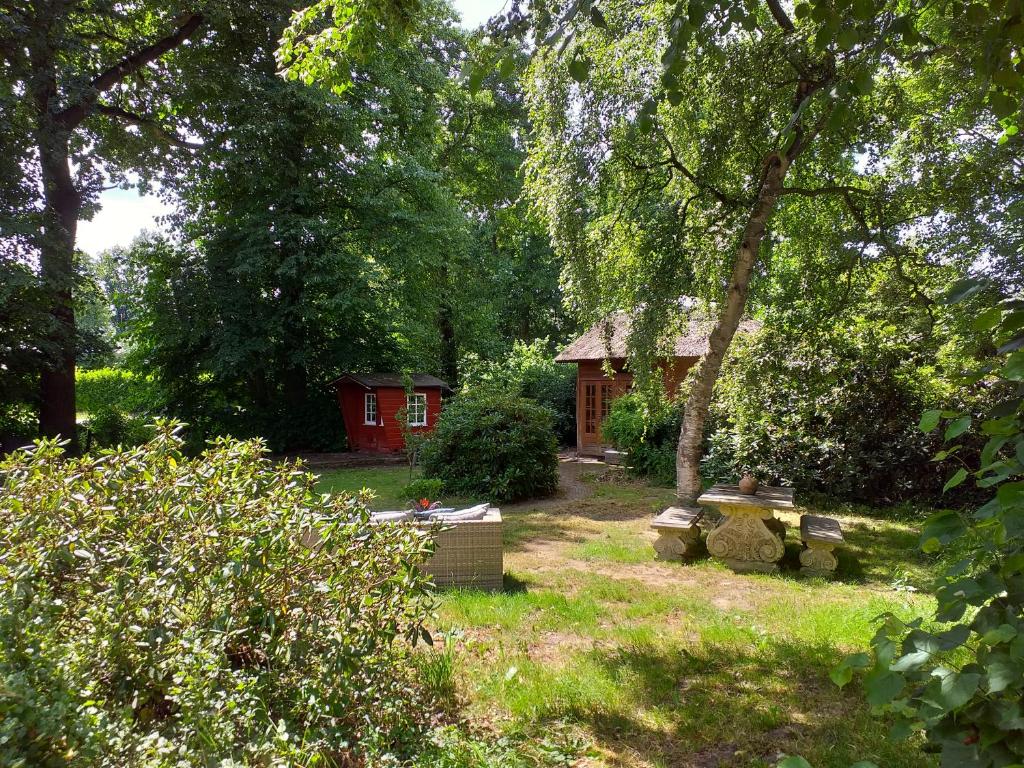 伊皮De Geheime Tuin - Huisje in 't Groen的花园的后面设有红色小屋