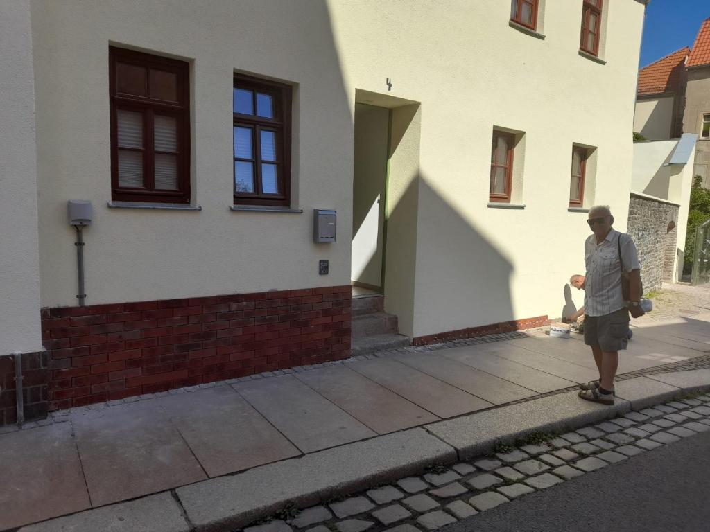 阿尔滕堡Kunstgasse 4+5的一个人在房子前面的人行道上滑板