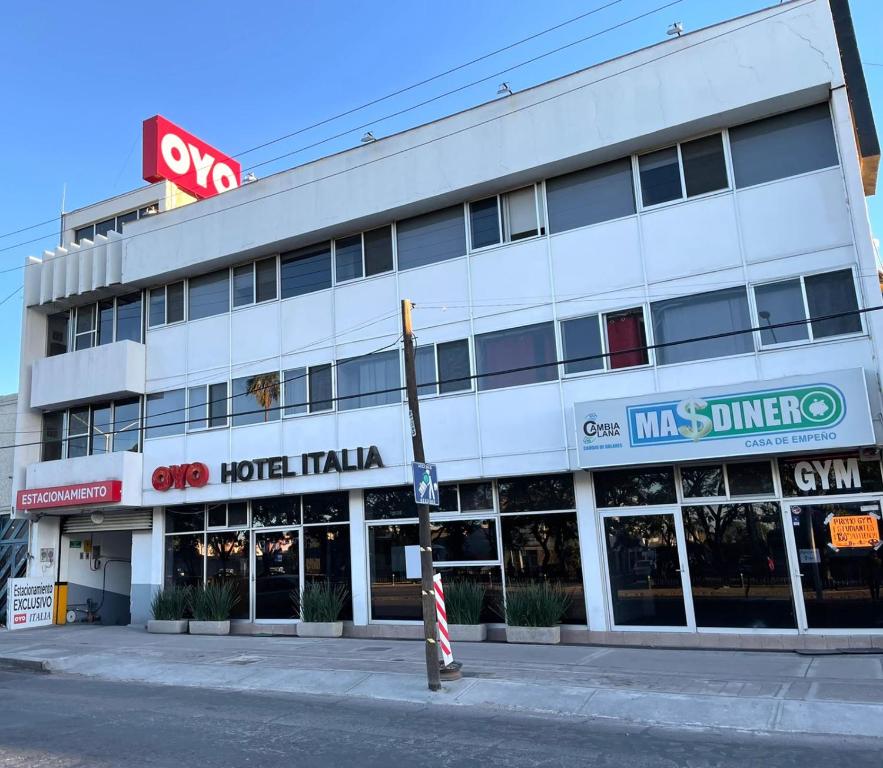 阿瓜斯卡连特斯Hotel Italia的街道角落上一座白色的大建筑