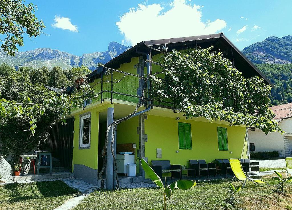 科巴里德Hiša Planica的黄色的房子前面设有桌椅