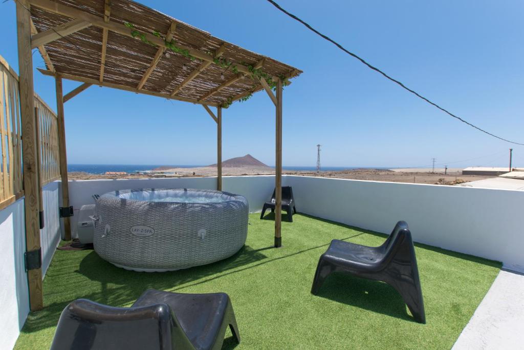 厄尔梅达诺La casita de Aitor; campo y playa en el Médano的屋顶上带桌椅的天井