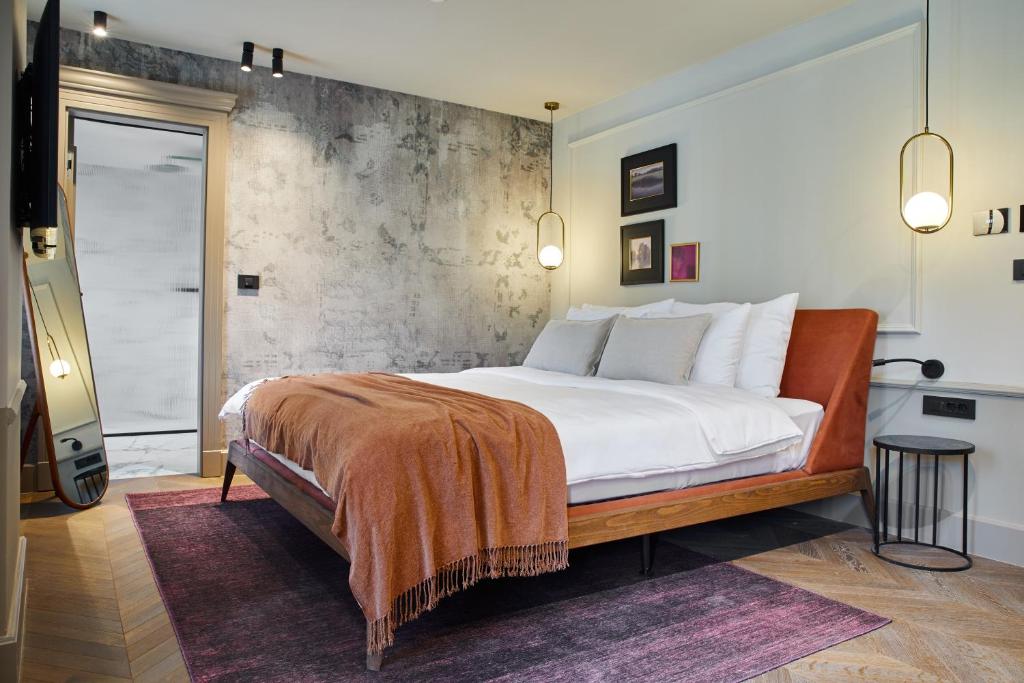 波雷奇Martis Forum Heritage Hotel & Residence的一间卧室设有一张带混凝土墙的大床