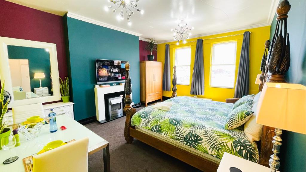 古耳PHOENIX Apartments的一间卧室配有一张床、一张书桌和一台电视