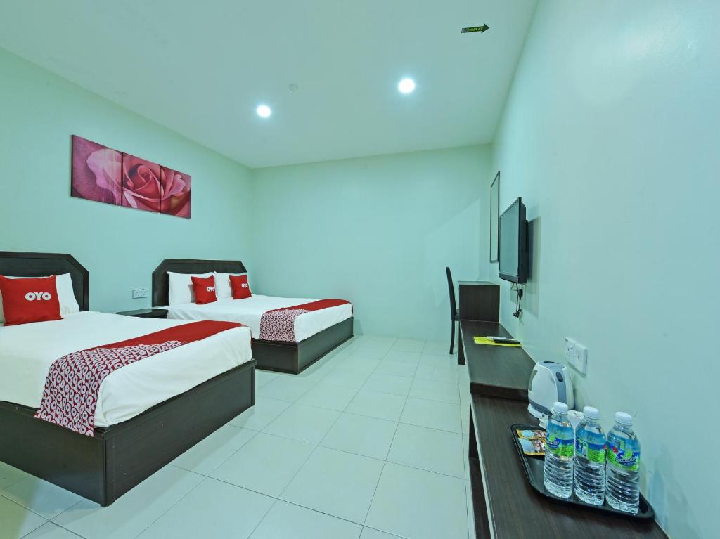 马六甲Super OYO Capital O 90545 Ho Hotel的一间酒店客房,设有两张床和电视