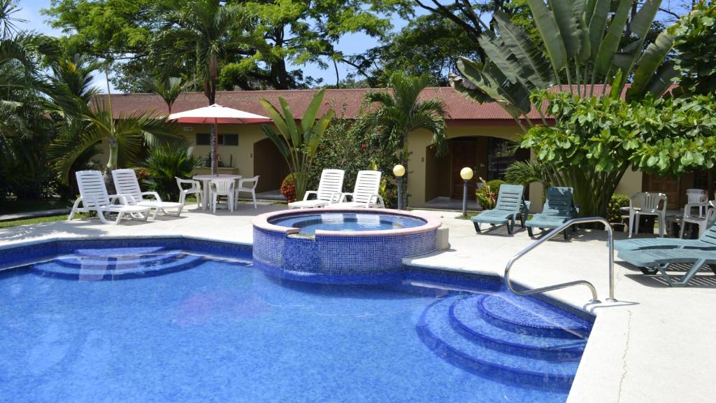 雅科Villa Creole的一个带椅子和桌子的游泳池以及一座房子